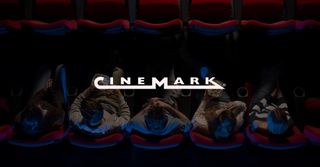People watching a movie with the cinemark logo above their eads