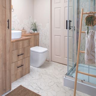 Bathroom with wooden furniture and ladder storage leaning against shower