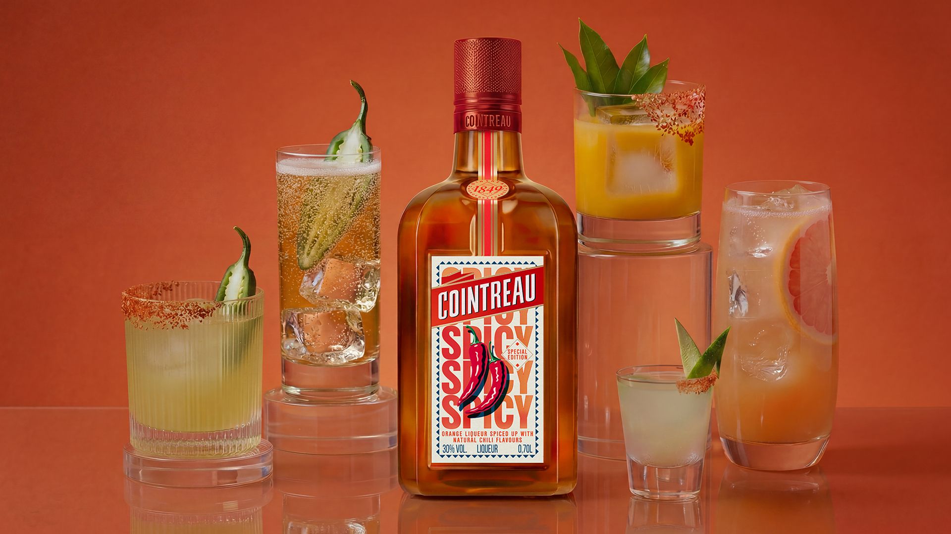 an image of the Cointreau spicy bottle with five different cocktails around it