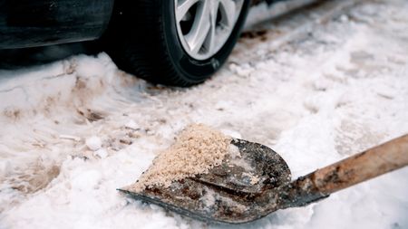 Salting driveway with shovel