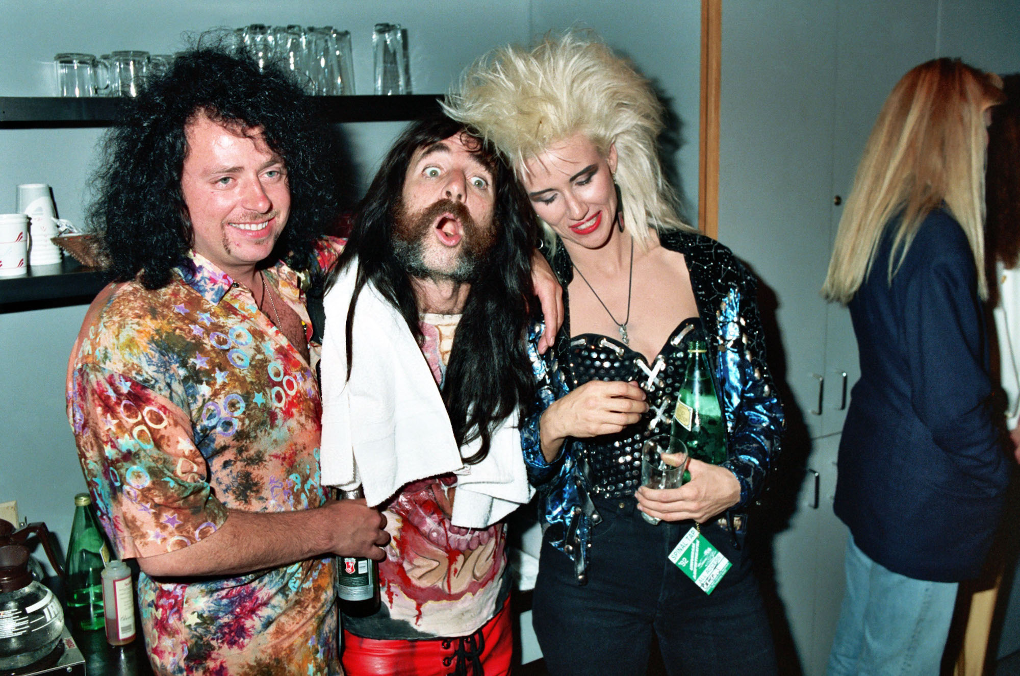 (from left) Steve Lukather, Derek Smalls, and Jennifer Batten, pictured backstage at the Universal Amphitheatre in Universal City, California in 1992