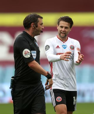 Michael Oliver, left, discusses the goal-line incident with Sheffield United's Oliver Norwood