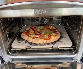 Midway through cooking a vegetable pizza in the Ninja Woodfire Outdoor Oven