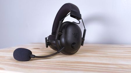 The Razer BlackShark V2 Pro with mic sitting on a wood table
