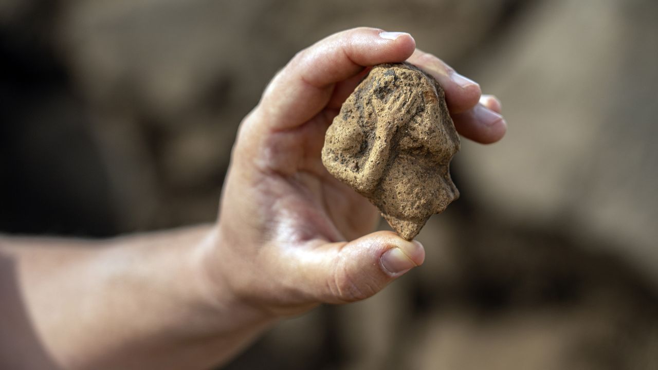 A portion of a figurine found at the Iron Age fort in Hispin. The figure appears to be a woman holding a drum.