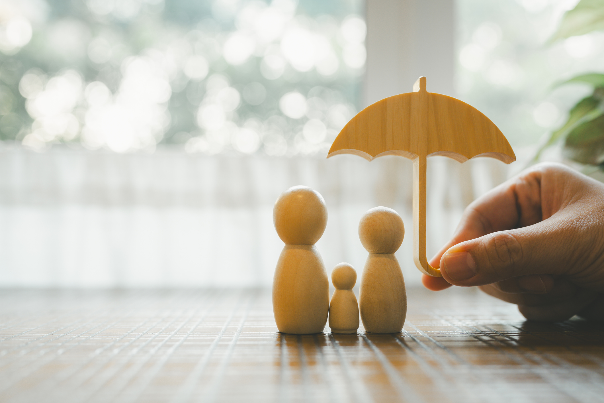 Hand holding a model umbrella over a model family