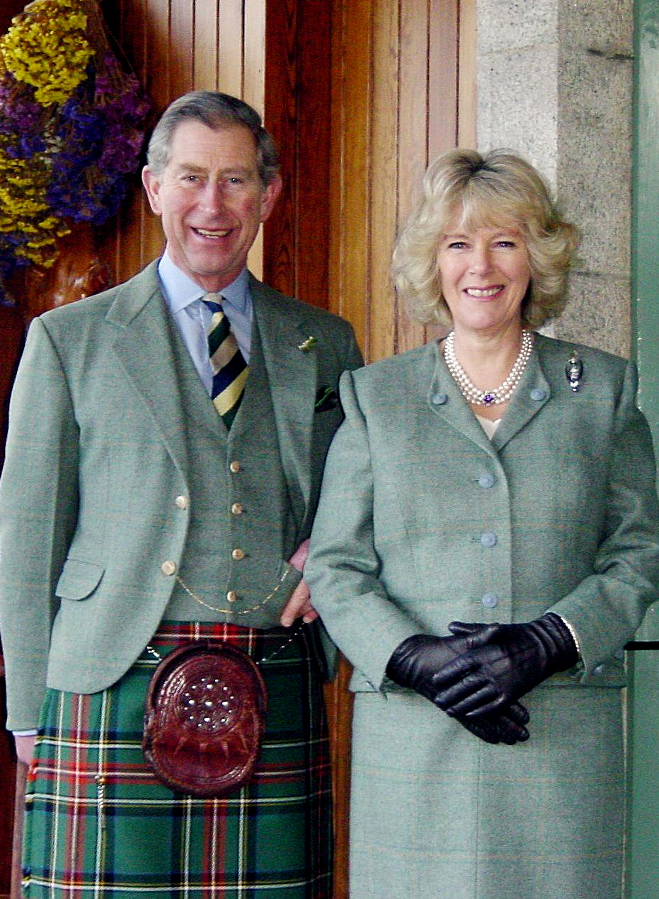 King Charles and Queen Camilla posing in green outfits after their engagement