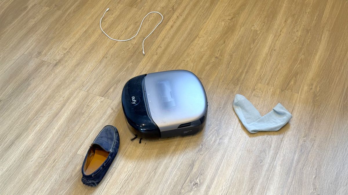 Eufy Omni S2 robot vacuum navigating between a sock and a shoe
