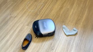 Eufy Omni S2 robot vacuum navigating between a sock and a shoe