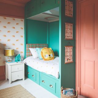 A children's bedroom with a built-in cabin bed in turquoise with contrasting coral door