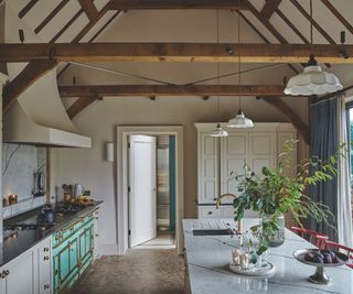 A neutral kitchen with a Christmas floral display and a tray of candles on the island