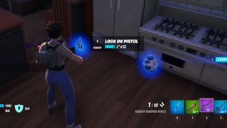 Fortnite - A player looks at a glowing blue gun on the ground called the Lock On Pistol