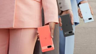 people in pink black and blue suits holding a pink, black, and blue Pixel 7a phone each