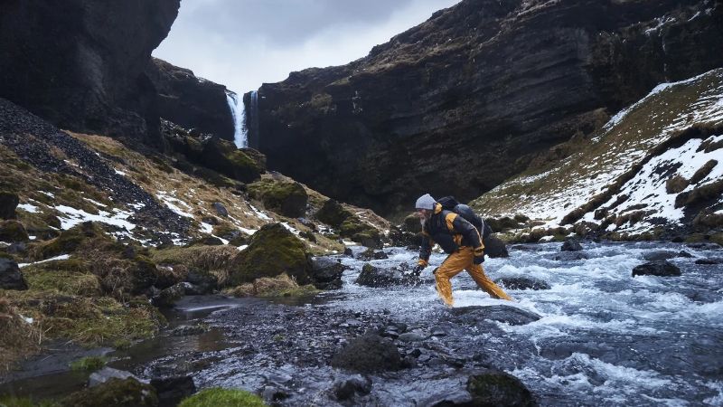 Hiker walking through river