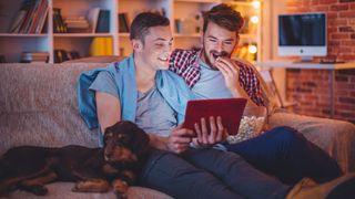 Couple watching movie on the couch with their dog