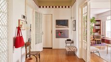 Image of a white open concept room. The ceiling is painted in an ochre yellow with a red and white stripe trim.