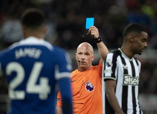 Referee Simon Hooper shows Reece James of Chelsea a red card during the Premier League match between Newcastle United and Chelsea FC at St. James Park on November 25, 2023 in Newcastle upon Tyne, England.