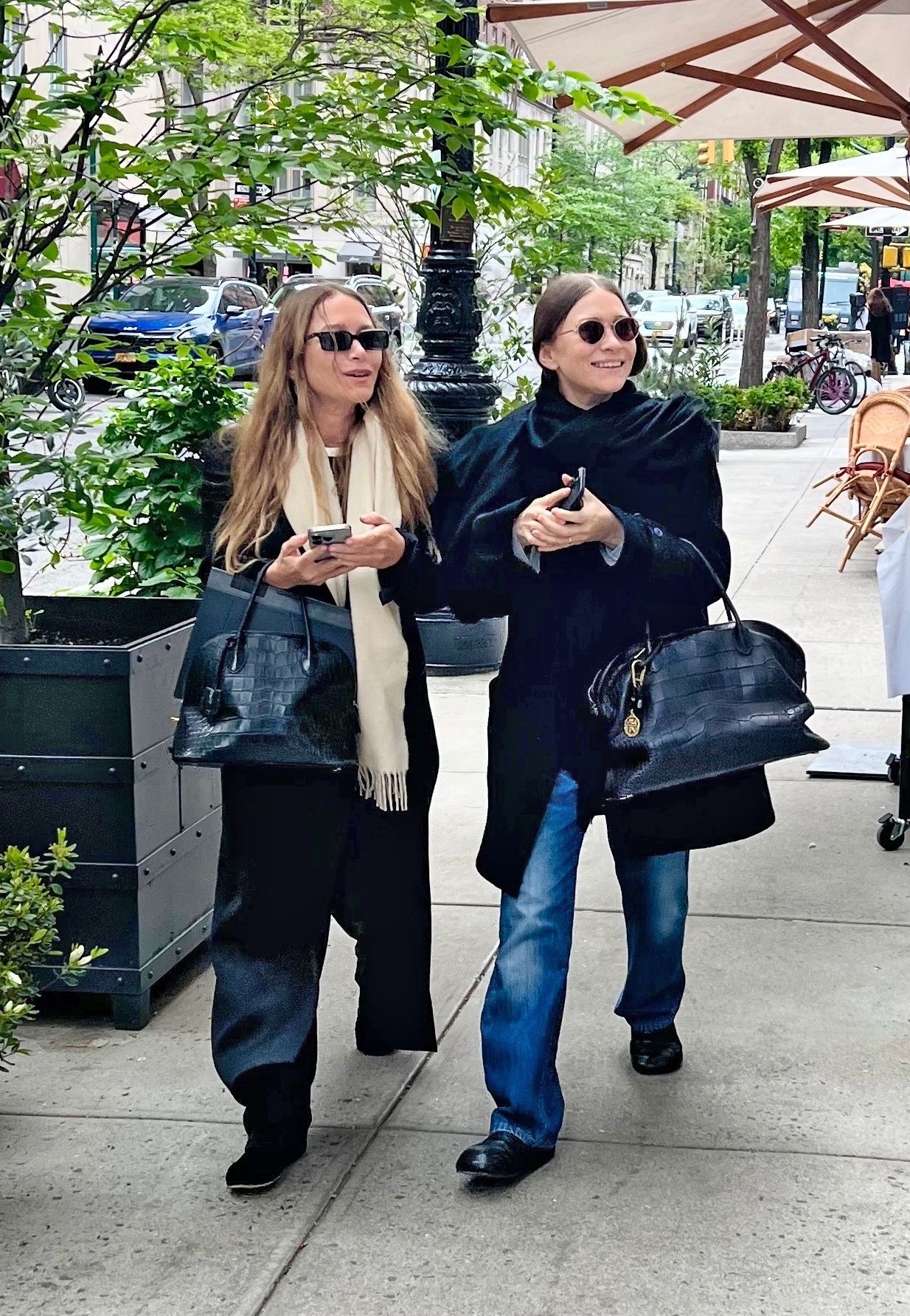 olsen twins walking together on the street carrying oversized croc bags