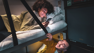 Two people in a sleeper train bedroom cabin