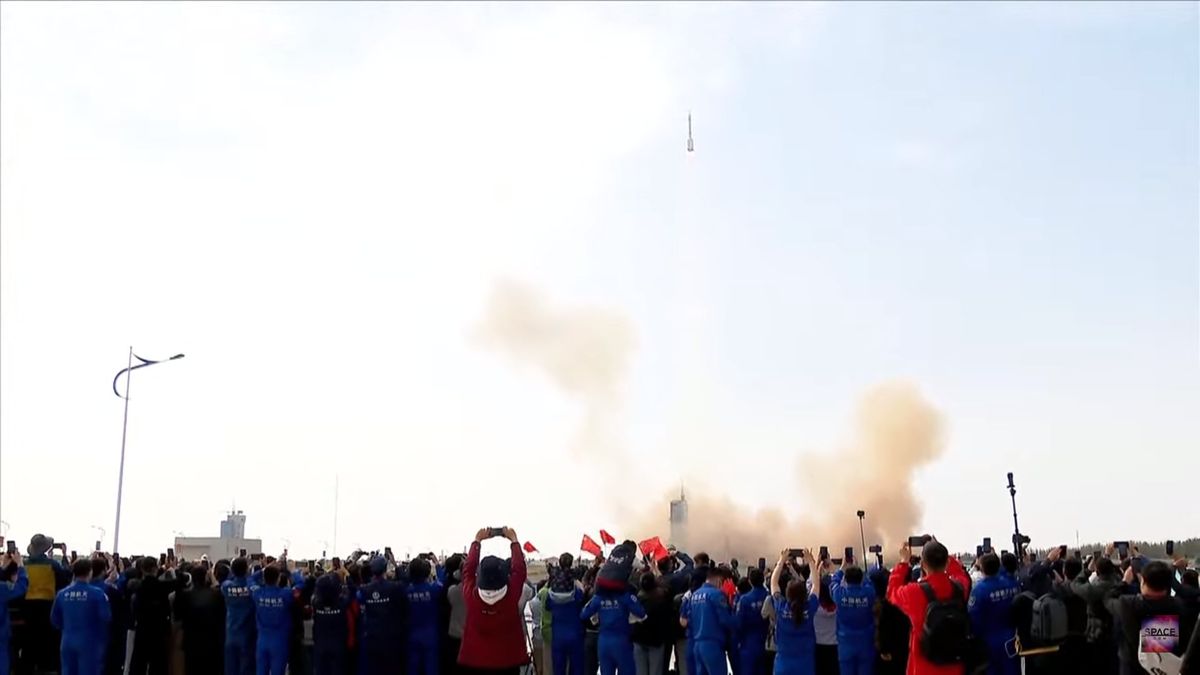 A crowd watches a Chinese rocket launch with 3 astronauts aboard