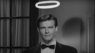 Roger Moore smirks at the camera with a halo in The Saint.