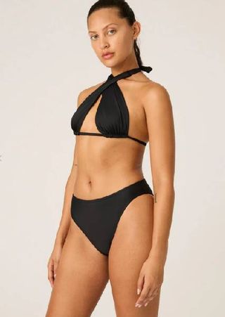 A model wearing a black bikini from Modibodi.