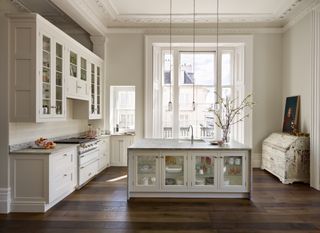 A white shaker style kitchen with large island with glass cabinets