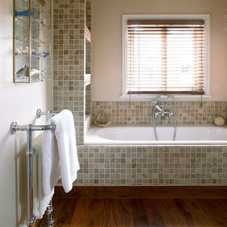 bathroom in edwardian home with mosaic limestone tiles and white bathtub