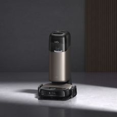 eufy Robot Vacuum Omni S2 on its dock on concrete floors with a dark background