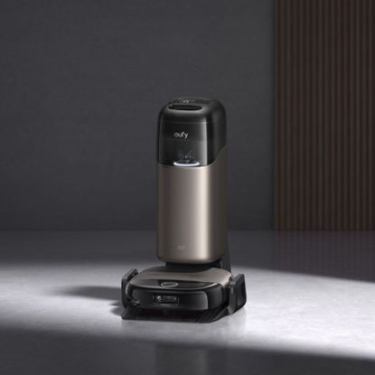 eufy Robot Vacuum Omni S2 on its dock on concrete floors with a dark background