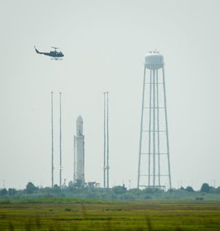 Security Helicopter Flies by Antares Rocket