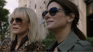 Cate Blanchett and Anne Hathaway looking forward smiling while wearing sunglasses in Ocean's 8.