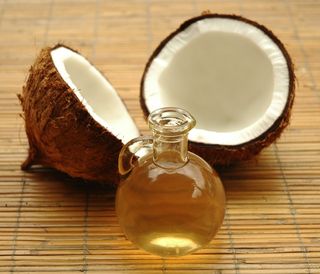 A coconut and a bottle of coconut oil