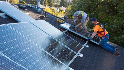 picture of men installing solar panels on a roof