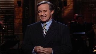 Phil Hartman grins on stage during his monologue on SNL.
