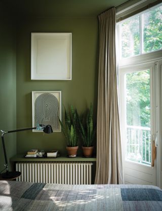 An olive green bedroom painted in Farrow & Ball green