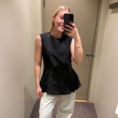 Woman wears black top, white jeans