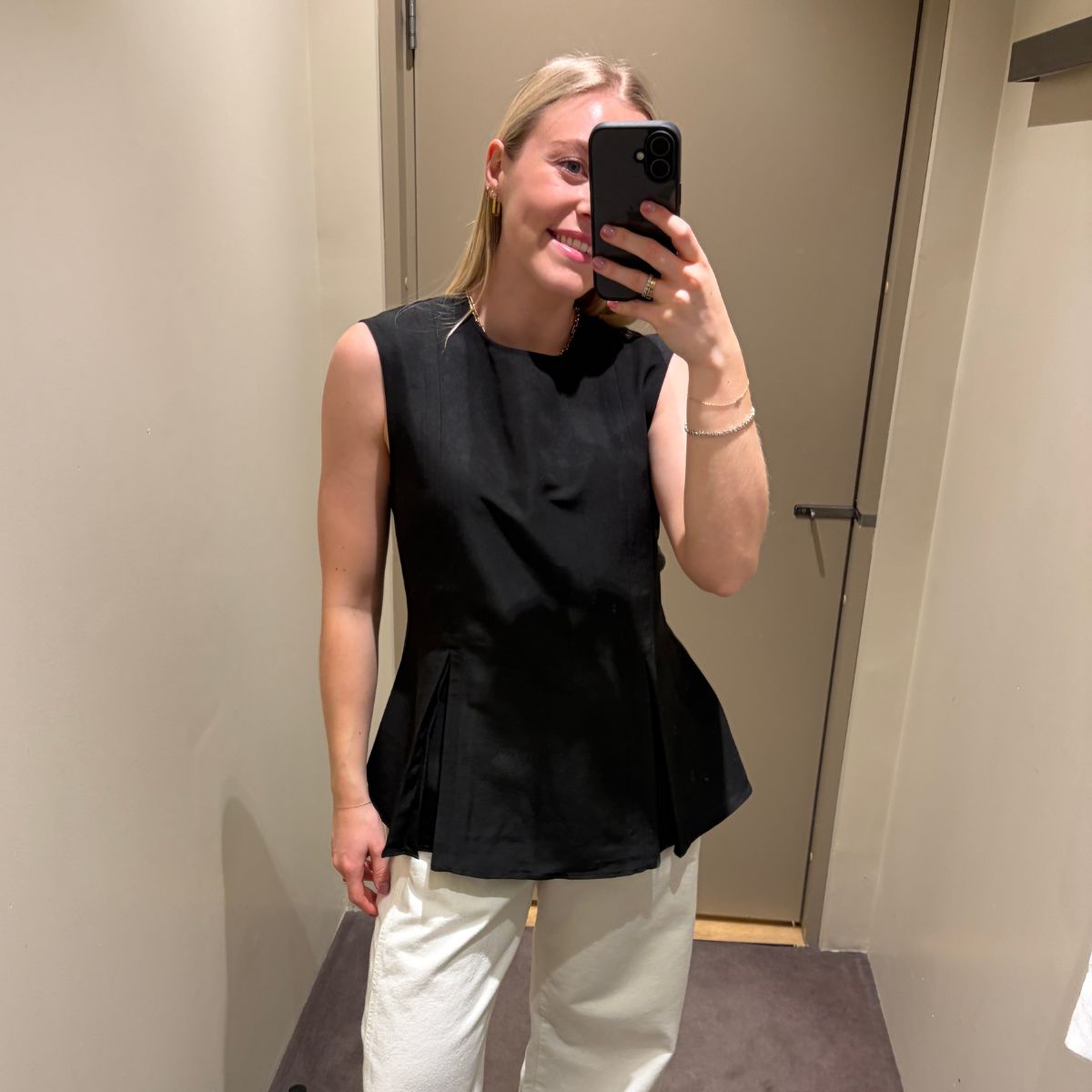Woman wears black top, white jeans