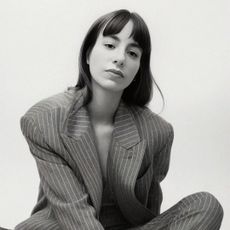 designer wray serna sitting in front of a backdrop