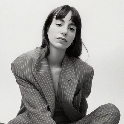 designer wray serna sitting in front of a backdrop