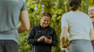 A man checks his phone on a hike