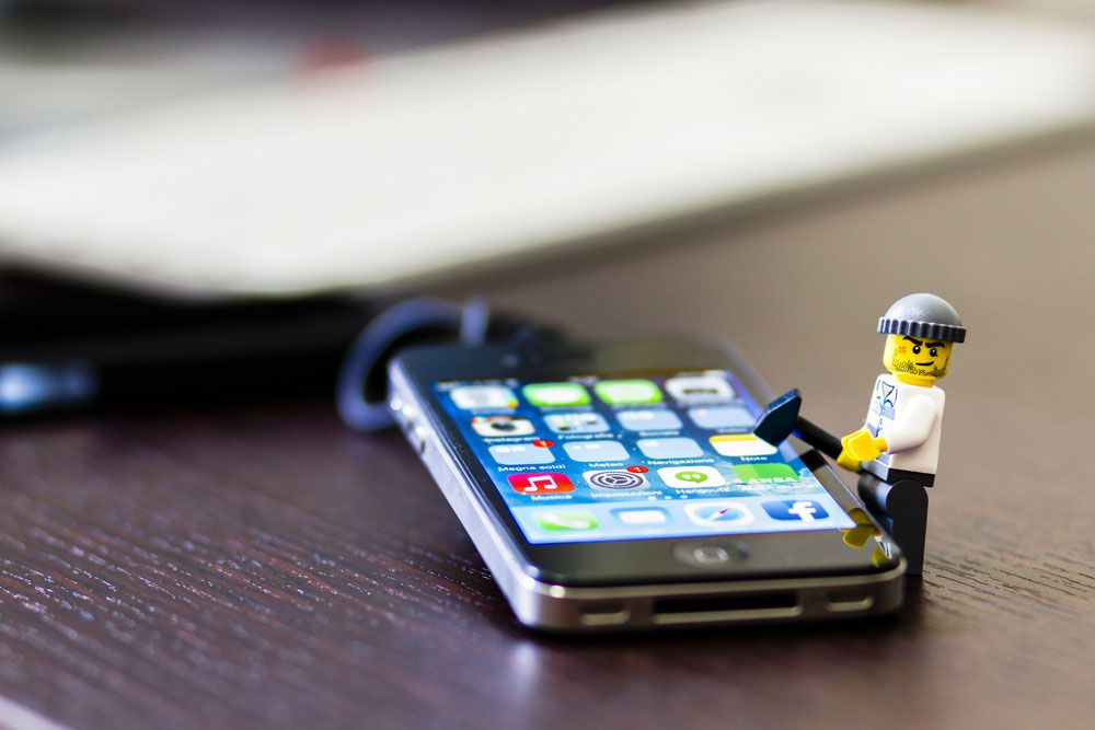 A Lego thief mini-figurine tries to break into an iPhone.