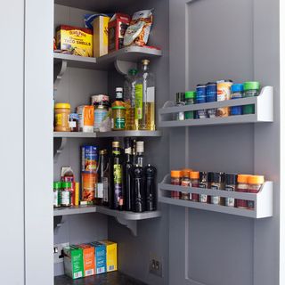 grey cuboard with corner shelves and door mounted spice racks