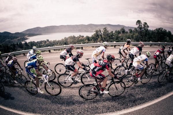 The peloton rides past a lake on the way out of Durango.