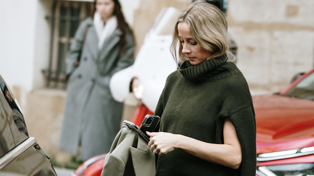 Woman wearing a green sweater vest in Paris. 