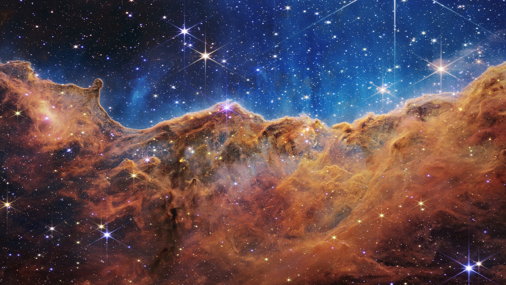 A composite image of the Cosmic Cliffs in the Carina Nebula, created with the Webb telescope's NIRCam and MIRI instruments.