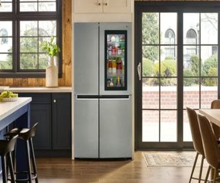 A kitchen with a fridge and metal frame windows