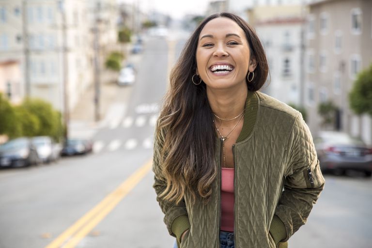 self-care day ideas - portrait of laughing young woman on the street