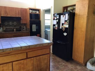 old kitchen with dark wood cabinets, black worktops and black fridge