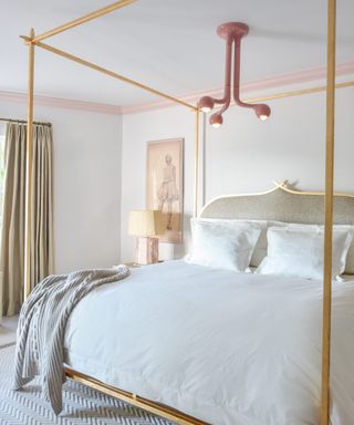 four poster bed with modern pink light above
